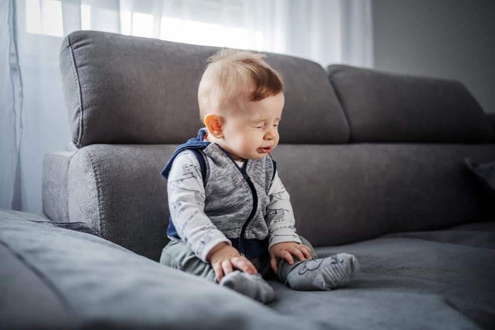 Sneezing baby on couch