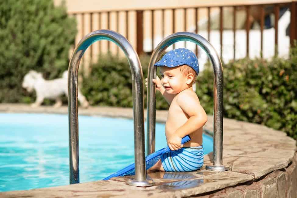 Toddler sitting on the side of a pool