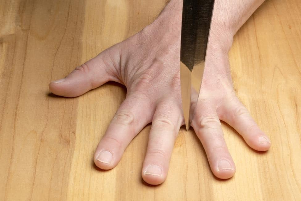 Tip of a knife in between fingers