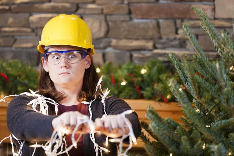 A person pluggin in Christmas lights