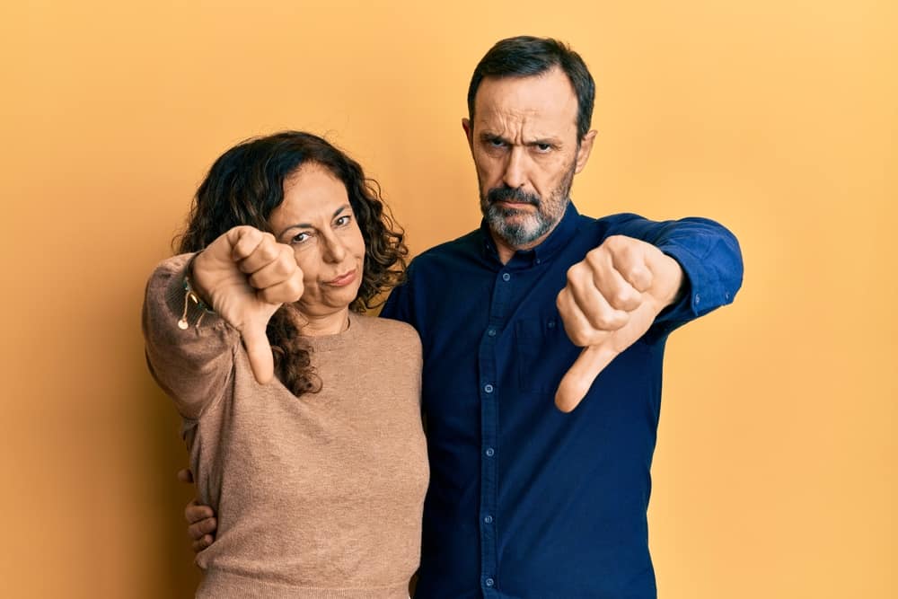 A couple give thumbs down gesture