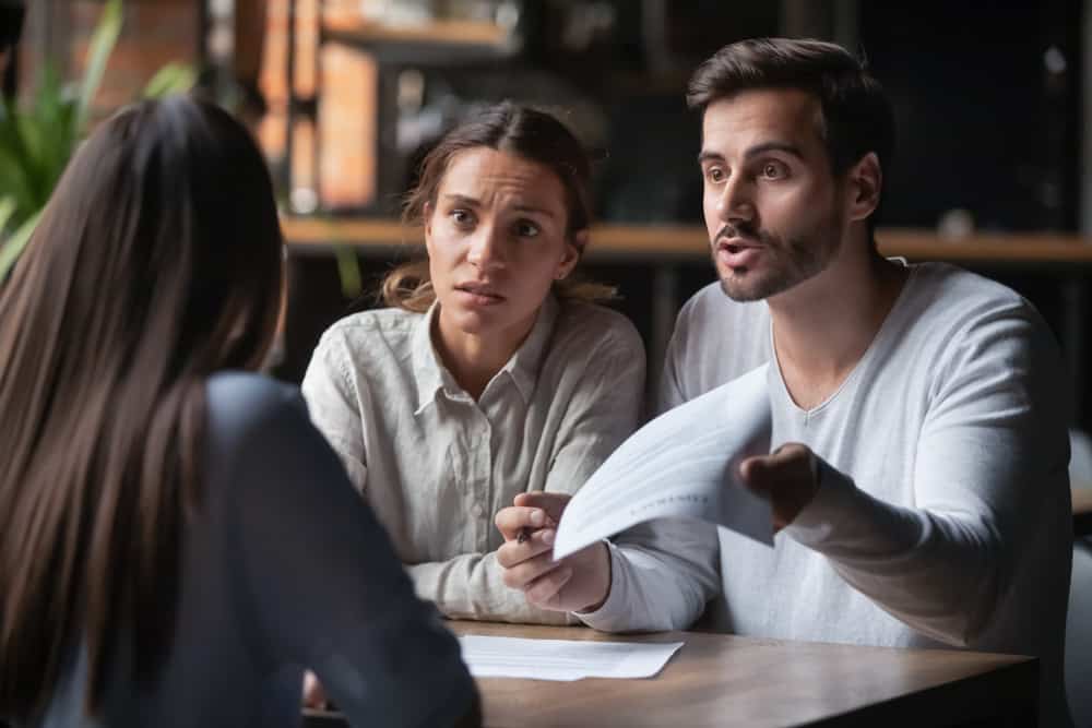 Annoyed couple talking to an agent