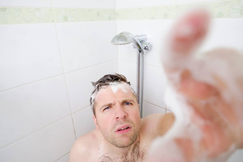 A man looking at a camera in a shower