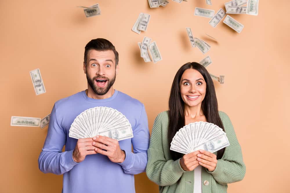 A happy couple holding money