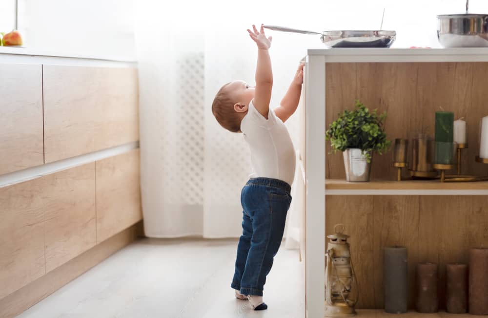 Child reaching for a pan
