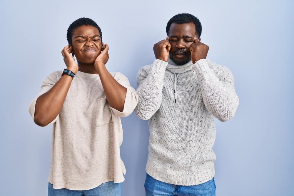 Two guys plugging their ears